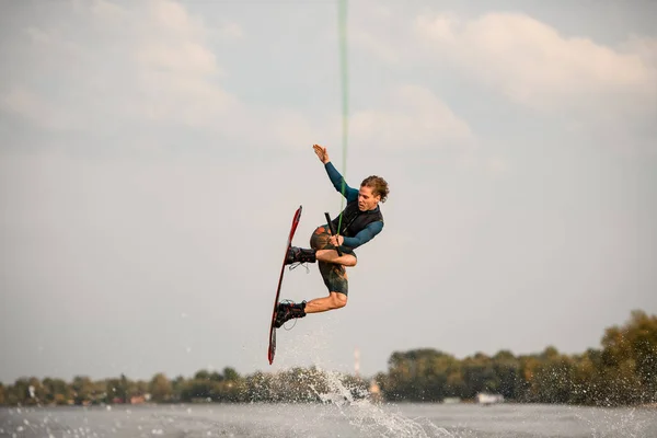 Vue du wakeboarder masculin sportif sautant haut au-dessus de l'eau de la rivière — Photo