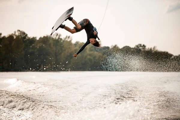 Extreme guy having fun on wakeboard jumps over splashing river water — Stock Photo, Image