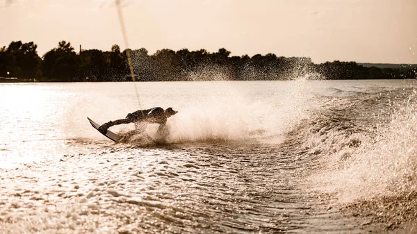 Belle vue des éclaboussures d'eau sur laquelle le jeune homme actif monte sur wakeboard — Photo