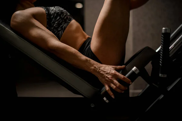 Primer plano de hermoso atlético musculoso brazo y cuerpo femenino en simulador de deportes —  Fotos de Stock