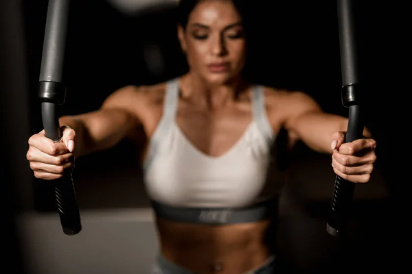 व्यायामशाळेत स्नायूंच्या गटासाठी मशीन वापरणार्या स्त्रीचे हात बंद-अप . — स्टॉक फोटो, इमेज