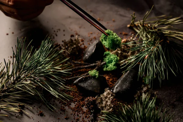 Main masculine tient ingrédient avec une pince à épiler et l'ajoute au plat de cuisine moléculaire moderne — Photo