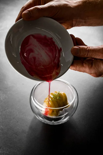 View of mans hand holding plate of syrup and pouring it over dessert — Stock Photo, Image