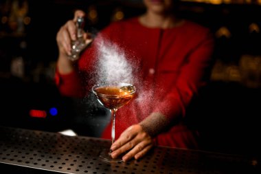 Barmen tarafından serpilmiş alkollü bir içecekle martini bardağı manzarası