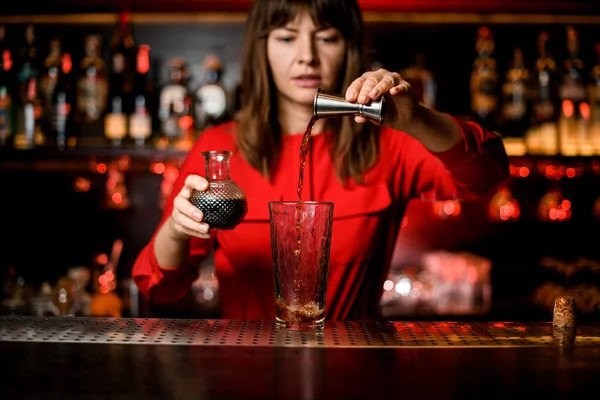Vista di vetro in cui la bevanda da jigger è versata da barista — Foto Stock