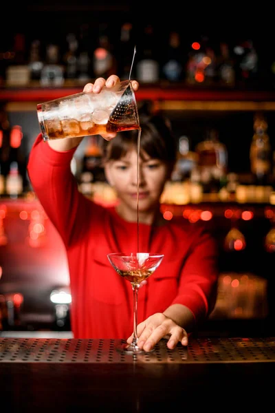 Vinagre fica em bar e bartender detém copo de mistura e habilidosamente derrama bebida nele — Fotografia de Stock