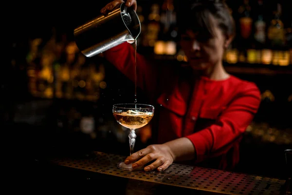 Vista de vidro brilhante com coquetel alcoólico frio em que o barman fêmea derrama bebida — Fotografia de Stock