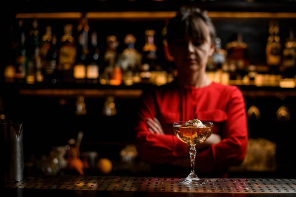 View on glass of alcoholic drink with ice cube stands on the bar counter — Stock Photo, Image