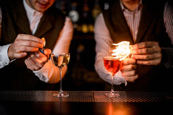 Vista de perto de copos com bebidas e bartenders polvilhar e colocá-los em chamas — Fotografia de Stock