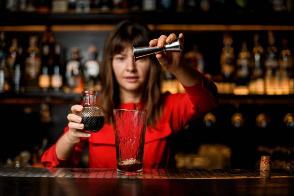 Stand di vetro su bar e barista femminile versa vino da jigger in esso — Foto Stock