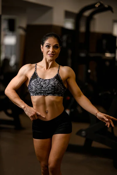 Vista frontal de la mujer fuerte y saludable en ropa deportiva de pie en el gimnasio —  Fotos de Stock