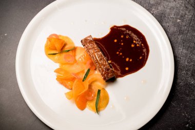 Lezzetli, sulu bir parça et, sos ve taze mandalina dilimleri..