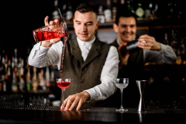 Barmenin bardan bardağa kokteyl döktüğü güzel bir manzara..