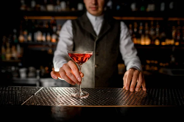 Belo vidro com bebida no bar e mão de homem barman segura — Fotografia de Stock