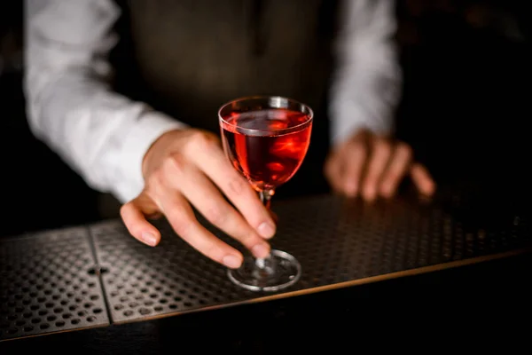 Gelas yang indah dengan minuman berdiri di bar counter tangan mans memegangnya — Stok Foto