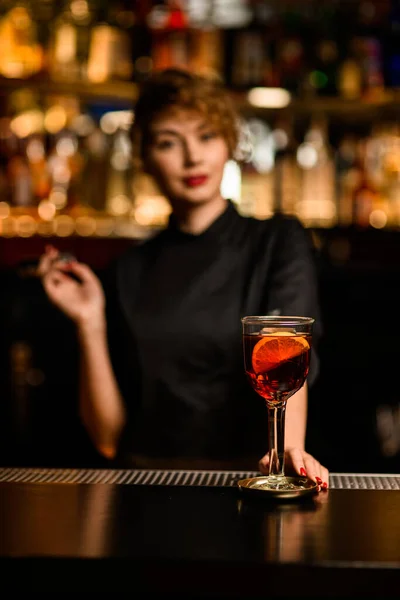 Glas met heldere alcoholische cocktail versierd met sinaasappelschijfjes op de bar — Stockfoto