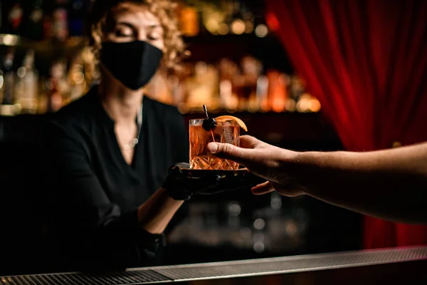 Mans mano toma vaso con cóctel de las manos de la mujer camarera — Foto de Stock