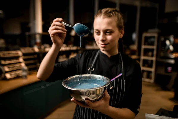 Mulher bonito chef prende tigela com molho azul e derrama-lo com colher — Fotografia de Stock