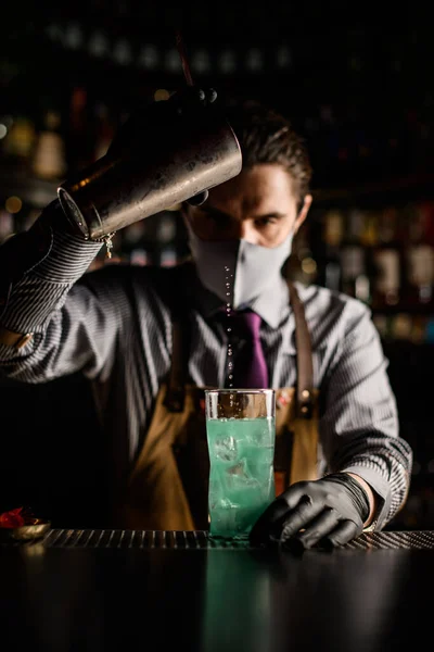 Vista frontal del camarero vertiendo cóctel azul de agitador de acero en la taza — Foto de Stock