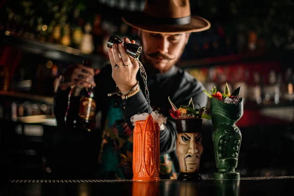 Camarero con estilo hábilmente vierte líquido en uno de los vasos de lujo en la barra —  Fotos de Stock