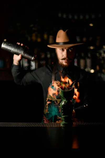 Hermoso vaso de bebida se encuentra en el bar y camarero prendiéndolo fuego en el fondo —  Fotos de Stock