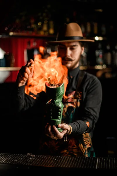 Camarero sostiene vidrio brillante con cóctel de hielo y lo prende fuego —  Fotos de Stock