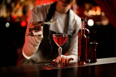 Bardağın içkiyle manzarası hangi barmen için için için yanan bir dalla süslenir