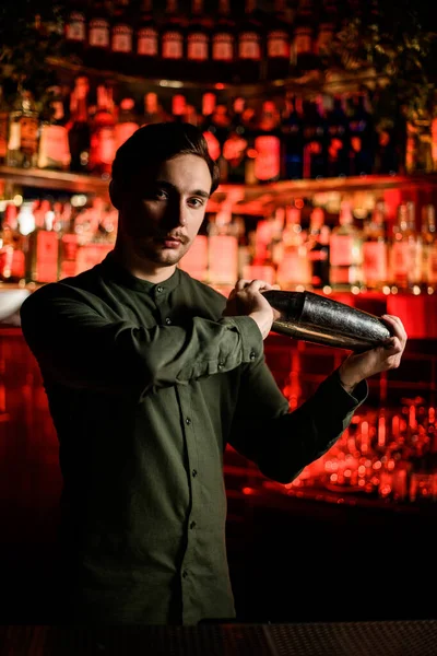 Blick auf schönen Mann Barkeeper stehend mit Stahl Shaker in seinen Händen — Stockfoto