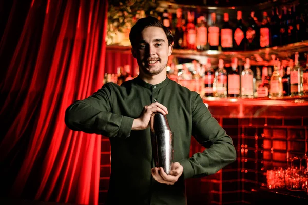 Jong glimlachende mannelijke barman staat met stalen shaker in zijn handen — Stockfoto
