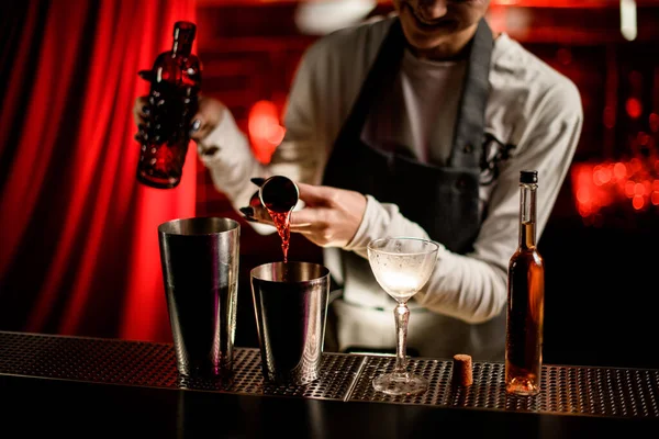 Close-up view of steel shaker cup in which bartender pours drink from jigger — Stock Photo, Image