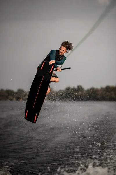 Przystojny atletyczny człowiek robi ekstremalny skok na wakeboard — Zdjęcie stockowe