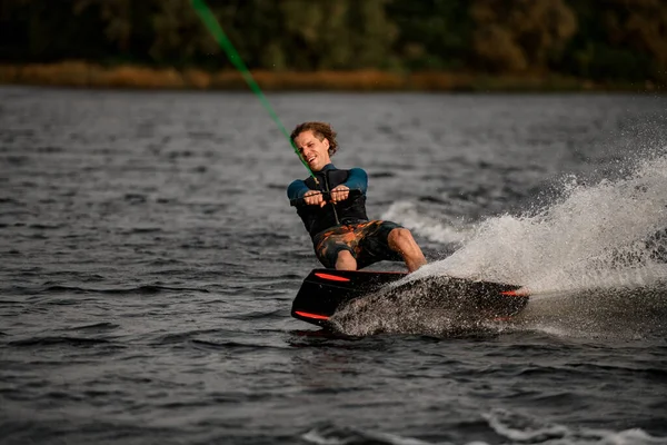 夏天的一天，运动员骑着滑板车沿河而下. — 图库照片