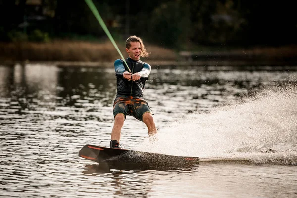 年轻快乐的小伙子积极地把他的闲暇时间花在玩滑板上. — 图库照片