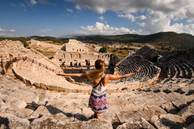 Antik Lycia şehri Patara 'nın amfi tiyatro kalıntılarında ellerini kaldırmış güzel bir kadın..