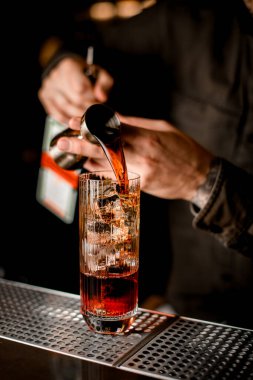 Barmen adamın zencefilden içtiği buzlu camın yakın plan görüntüsü.