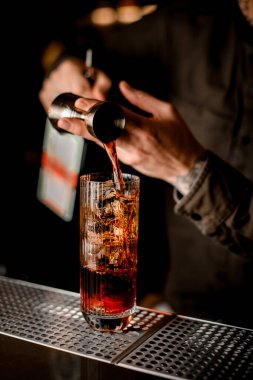 Buz küplü cam manzarası barmenlerin dikkatle doldurduğu jigger.