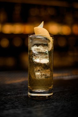 Güzel kristal bardak soğuk içecekle süslenmiş portakal kabuğu tezgahta.