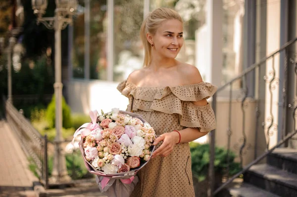 Magnifica vista della giovane donna bionda con splendido bouquet di fiori nelle sue mani — Foto Stock