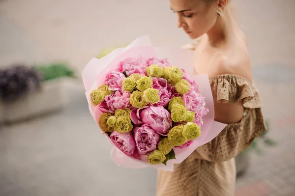 여인의 손에 있는 분홍빛 꽃 과 녹색 장미로 된 놀라운 꽃다발 — 스톡 사진
