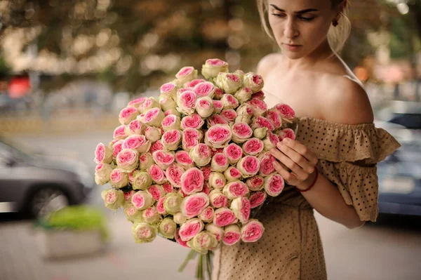 Bela mulher com grande buquê de rosas em suas mãos — Fotografia de Stock