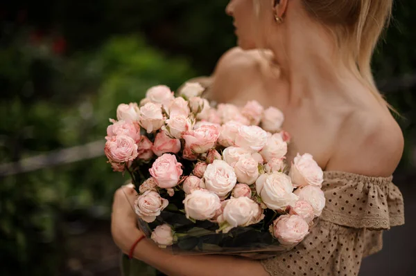 年轻女子手里拿着一束美丽而精致的浅粉玫瑰 — 图库照片