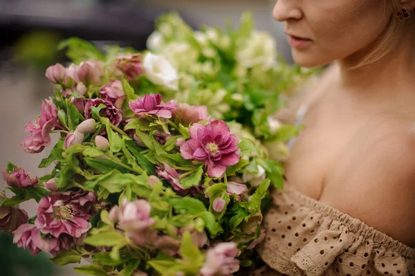 Vista da vicino su mazzo di fiori colorati e foglie verdi nelle mani della donna — Foto Stock