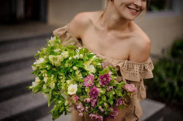 Splendido mazzo di fiori colorati e foglie verdi nelle mani della donna — Foto Stock