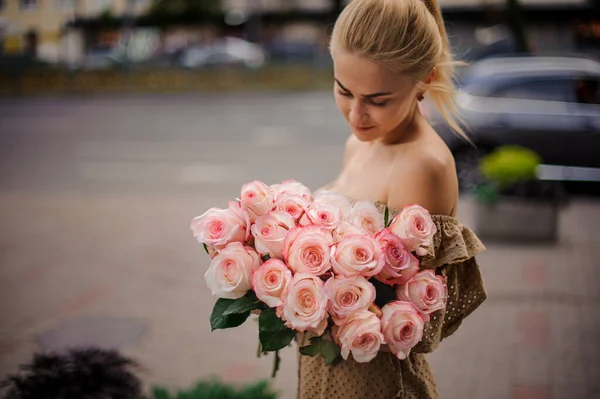 Wonderful bouquet of beautiful pink roses in the hands of young blonde woman — Stock Photo, Image