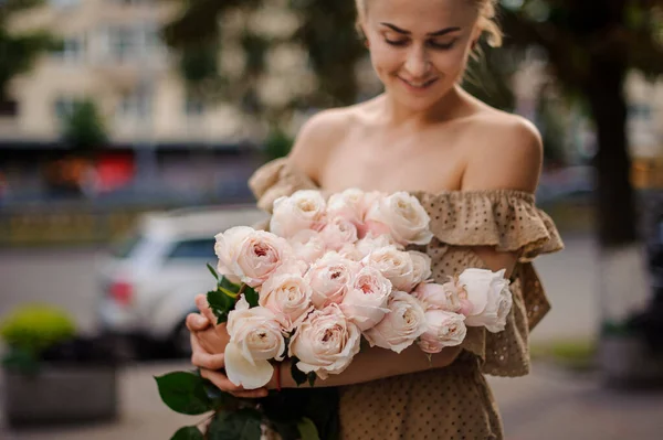 Great bouquet of beautiful cream roses in the hands of young smiling woman — 图库照片