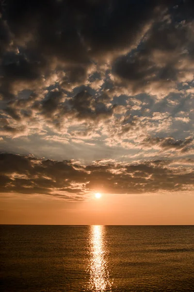 Expanse of the sea against beautiful sunset sky. Sun rays reflected in water. — Stock Photo, Image