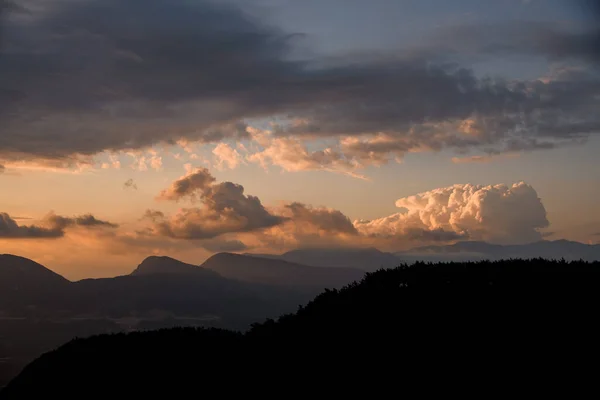 Vista do céu com grandes nuvens coloridas sobre a silhueta da montanha. Beleza na natureza. — Fotografia de Stock