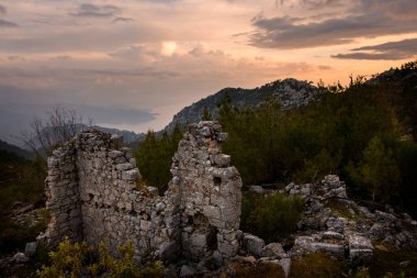 Dağın tepesindeki eski bina kalıntıları. Arka planda güzel manzara ve bulutlu gökyüzü