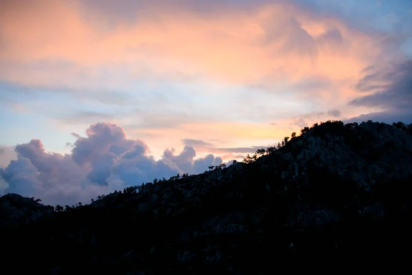 Bela vista sobre o céu e nuvens ao nascer do sol. Silhuetas escuras de montanhas ao amanhecer. — Fotografia de Stock