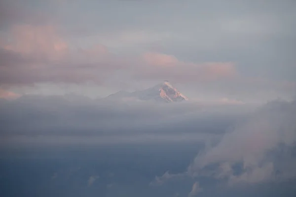 Dağın tepesinde harika bir manzara Sabah gökyüzünün altında Büyük beyaz bulutlarla. — Stok fotoğraf